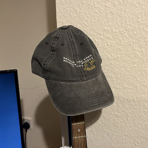 Grey hat with white embroidered text and yellow embroidered bear